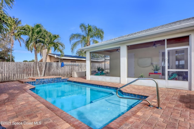 view of swimming pool featuring ceiling fan, a patio area, and a sunroom