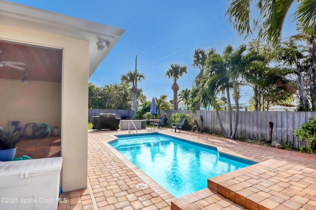 view of swimming pool featuring ceiling fan and a patio