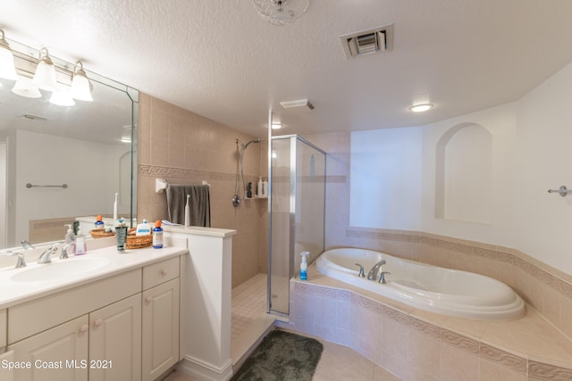 bathroom featuring tile patterned flooring, a textured ceiling, vanity, and shower with separate bathtub