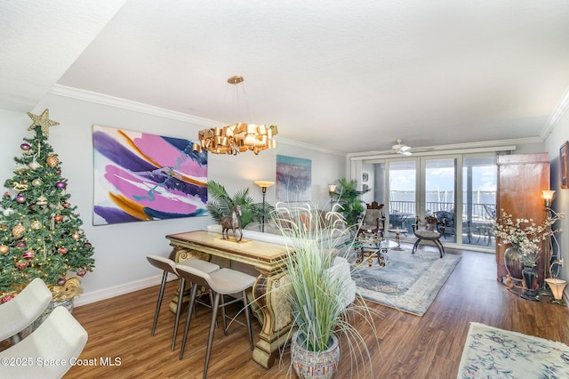 dining room featuring dark hardwood / wood-style floors, crown molding, and a notable chandelier