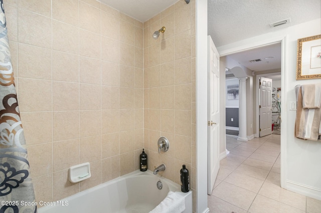 bathroom with a textured ceiling, tile patterned floors, ornate columns, and shower / tub combo