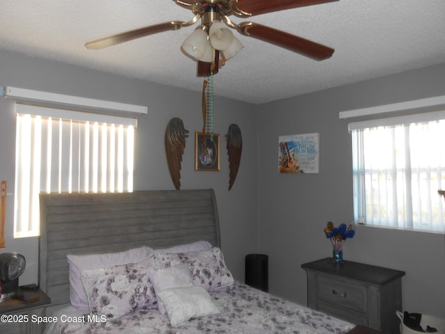 bedroom with ceiling fan and a textured ceiling