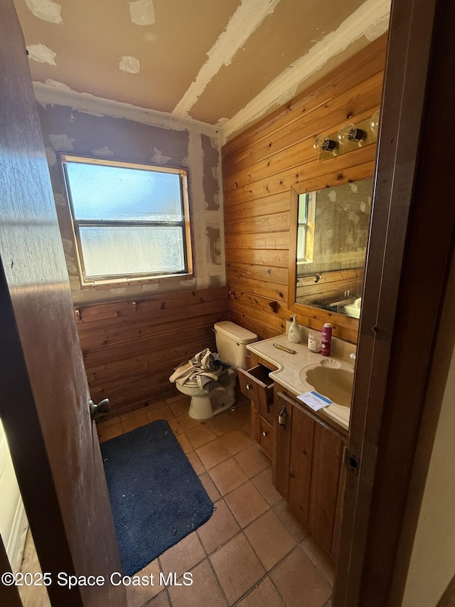 bathroom featuring vanity, wood walls, a bidet, tile patterned floors, and toilet