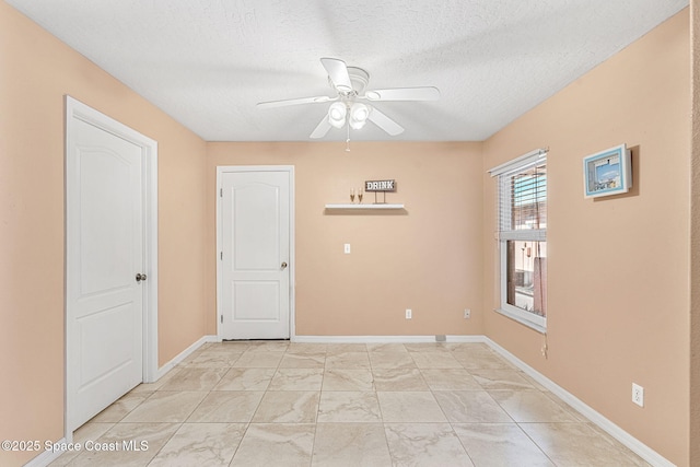 empty room with a textured ceiling and ceiling fan