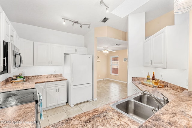 kitchen with ceiling fan, white cabinetry, sink, stove, and white fridge