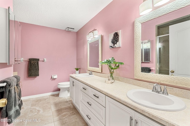 bathroom featuring vanity, toilet, and a shower with shower door