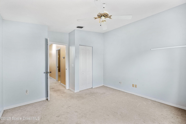 unfurnished bedroom featuring ceiling fan, a closet, and light carpet