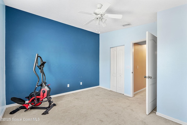 exercise area featuring ceiling fan and light carpet