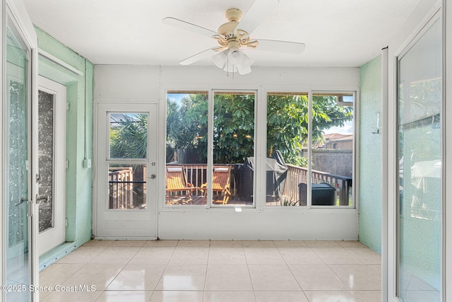 unfurnished sunroom with ceiling fan and a wealth of natural light