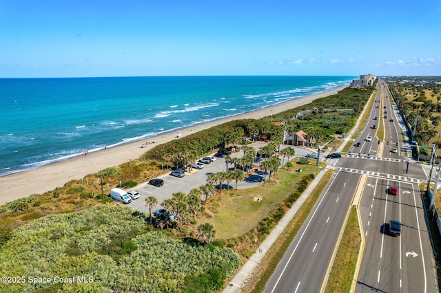 birds eye view of property featuring a beach view and a water view