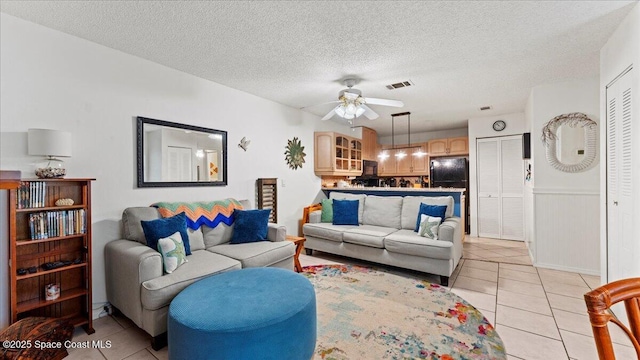 tiled living room featuring ceiling fan and a textured ceiling