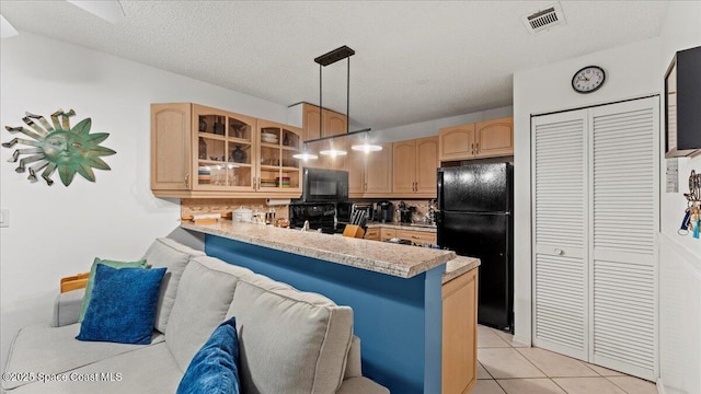 kitchen with decorative light fixtures, a breakfast bar, kitchen peninsula, and black appliances