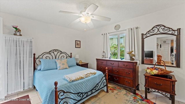 tiled bedroom featuring ceiling fan and a textured ceiling