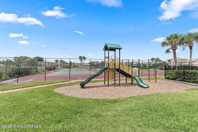 view of jungle gym featuring a lawn and tennis court