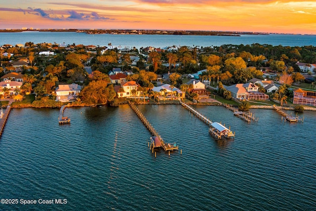 aerial view at dusk featuring a water view