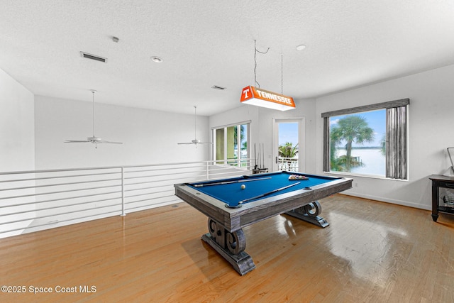 recreation room with a textured ceiling, light hardwood / wood-style flooring, ceiling fan, and billiards