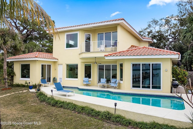 rear view of house with a patio area and a balcony