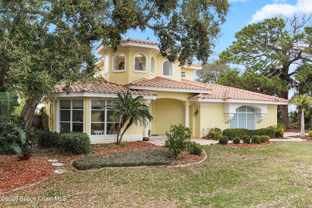 mediterranean / spanish house with a front lawn