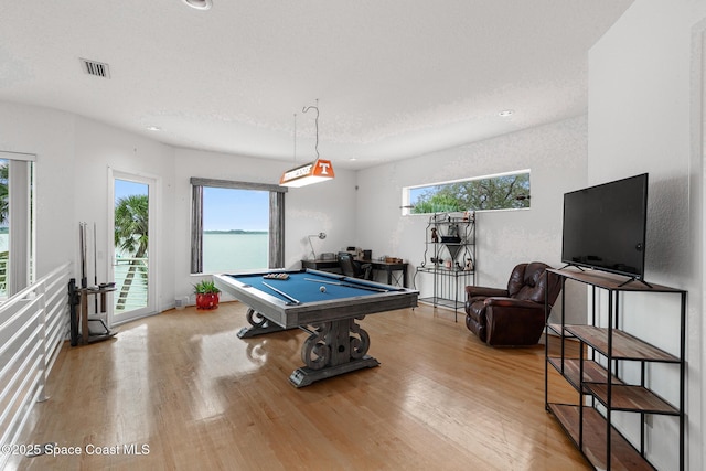 playroom featuring a textured ceiling, light wood-type flooring, and billiards