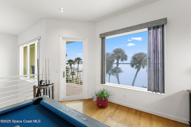 game room featuring a water view, wood-type flooring, and pool table