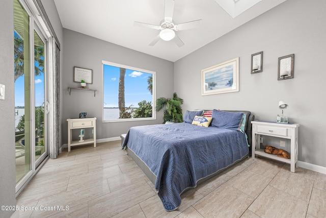 bedroom with ceiling fan, access to exterior, and a skylight