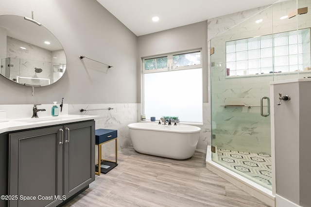 bathroom with vanity, tile walls, and independent shower and bath