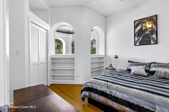 bedroom featuring hardwood / wood-style floors, ceiling fan, and lofted ceiling