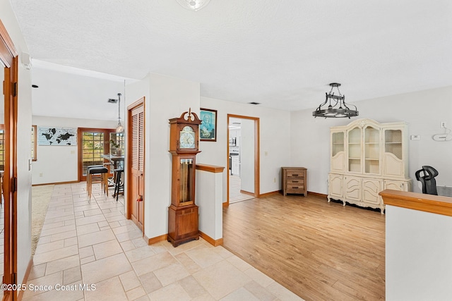 interior space featuring a notable chandelier, light hardwood / wood-style floors, and a textured ceiling