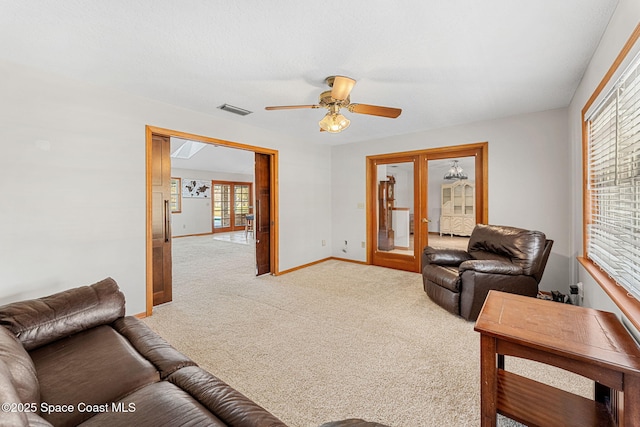 living room with french doors, light colored carpet, and ceiling fan