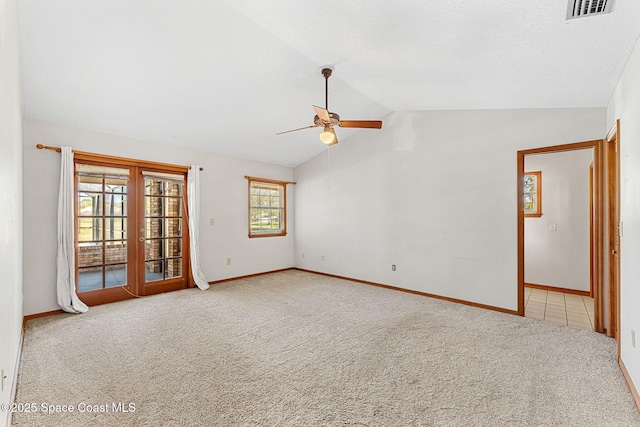 unfurnished room with french doors, lofted ceiling, a textured ceiling, ceiling fan, and light colored carpet