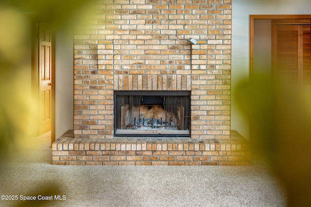 interior details featuring a fireplace and carpet flooring