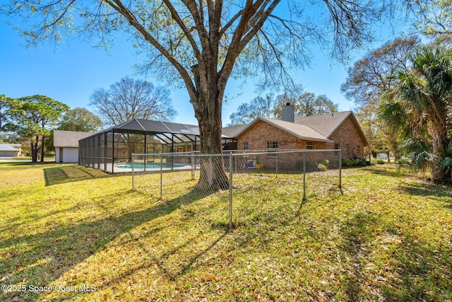 view of yard featuring a fenced in pool and glass enclosure