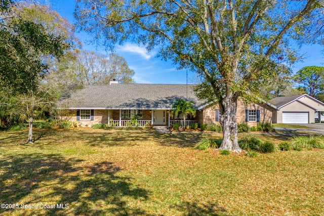 single story home featuring a garage, covered porch, and a front yard