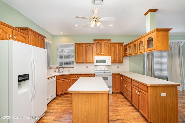 kitchen with white appliances, light hardwood / wood-style flooring, and a kitchen island