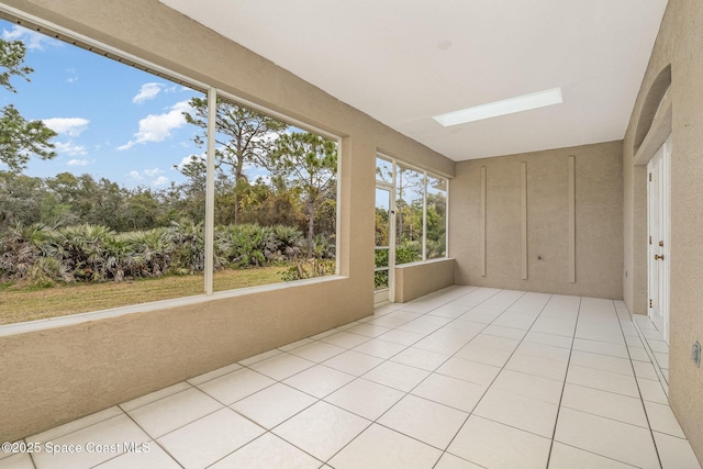 unfurnished sunroom featuring a skylight