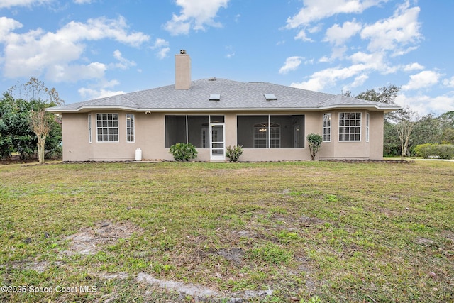 rear view of property with a sunroom and a lawn