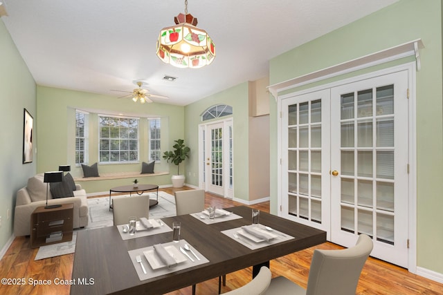 dining area with hardwood / wood-style floors, ceiling fan, and french doors