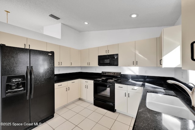 kitchen with sink, a textured ceiling, cream cabinetry, light tile patterned floors, and black appliances