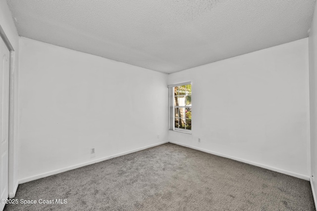 unfurnished room featuring carpet flooring and a textured ceiling