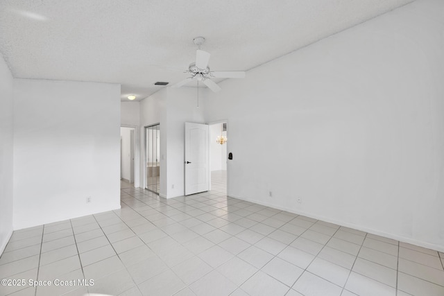 spare room with ceiling fan, light tile patterned floors, and a textured ceiling