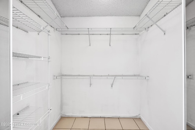 spacious closet with light tile patterned floors