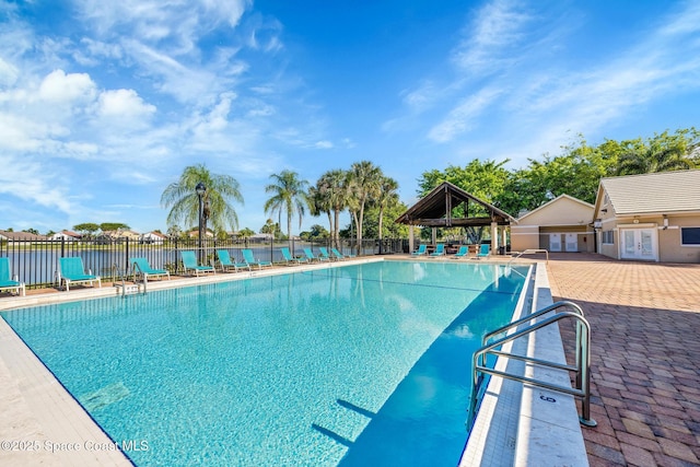 view of pool with a water view and a patio area