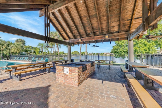 view of patio / terrace featuring ceiling fan, area for grilling, and exterior bar