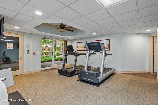 workout room featuring carpet floors, ceiling fan, and a paneled ceiling