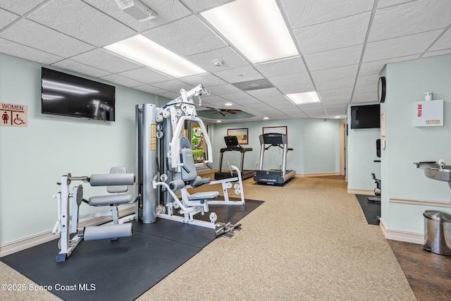 workout room featuring a paneled ceiling and dark carpet