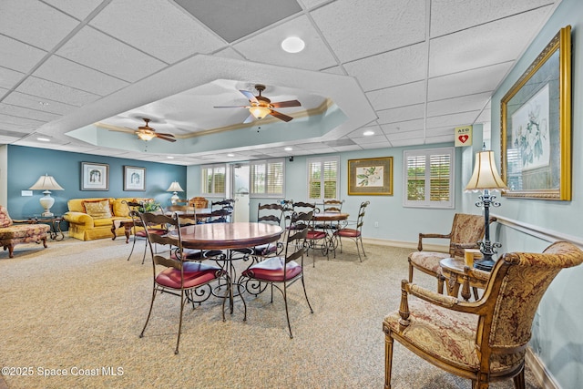 dining room with a drop ceiling, carpet flooring, ceiling fan, and a tray ceiling