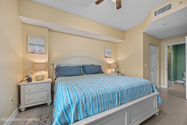 tiled bedroom with ceiling fan and connected bathroom