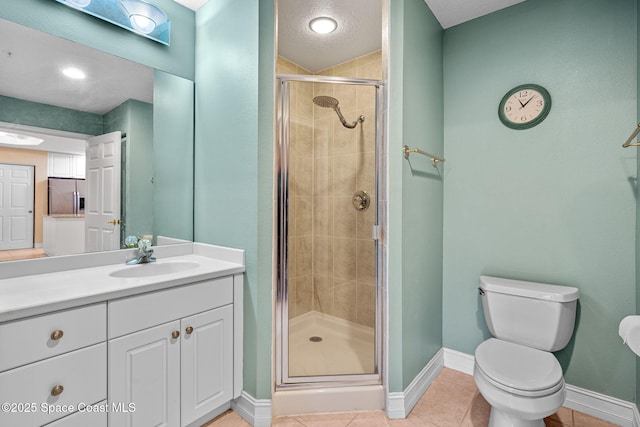 bathroom with tile patterned flooring, an enclosed shower, vanity, and toilet