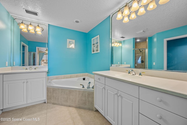 bathroom with tile patterned floors, vanity, a textured ceiling, and separate shower and tub