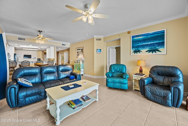 tiled living room with a textured ceiling, ceiling fan, and crown molding